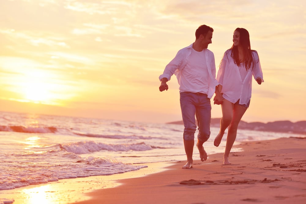 happy young romantic couple in love have fun on beautiful beach at beautiful summer day